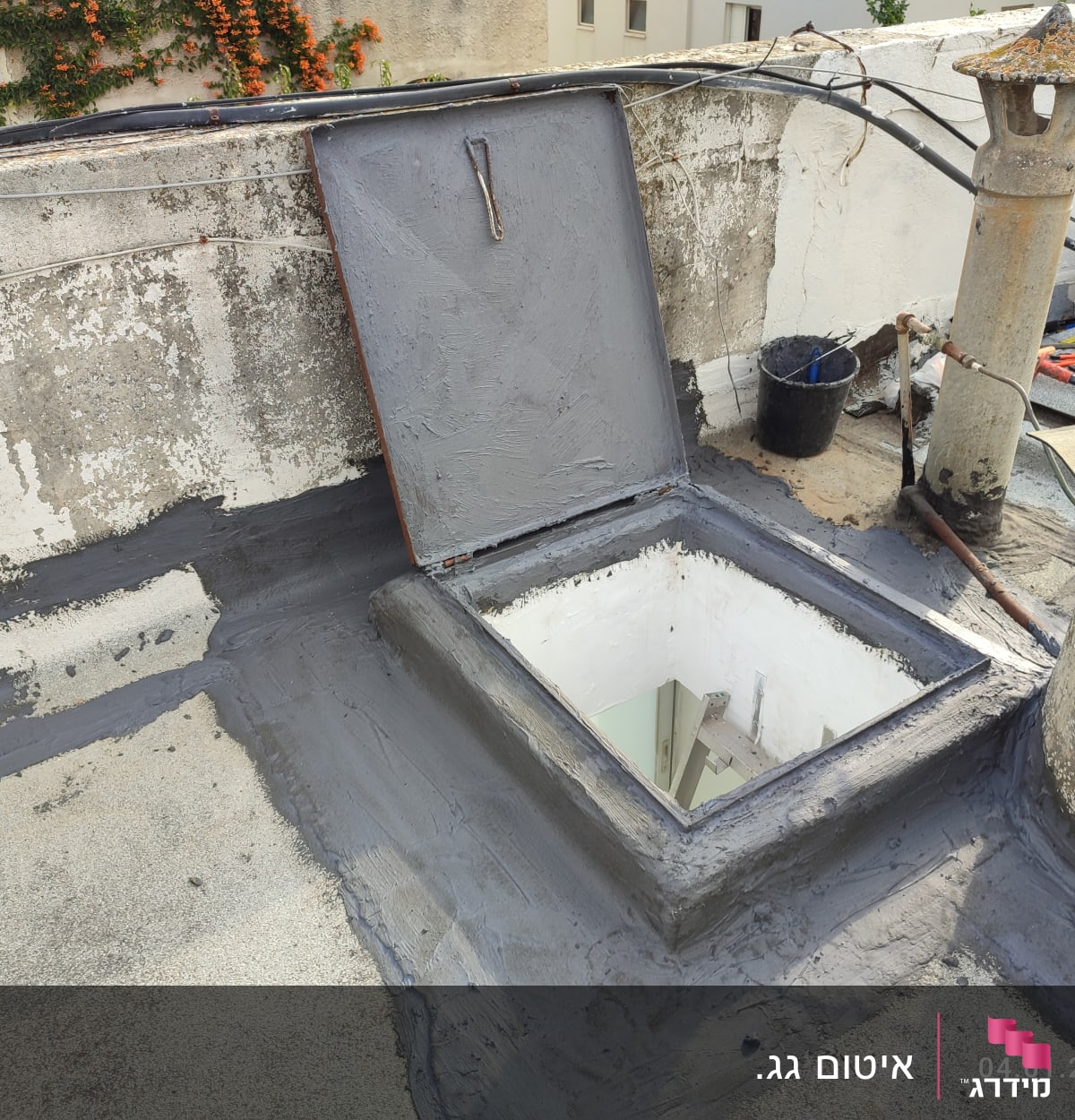 איטום גג עם חומר אפור סביב פתח מרובע